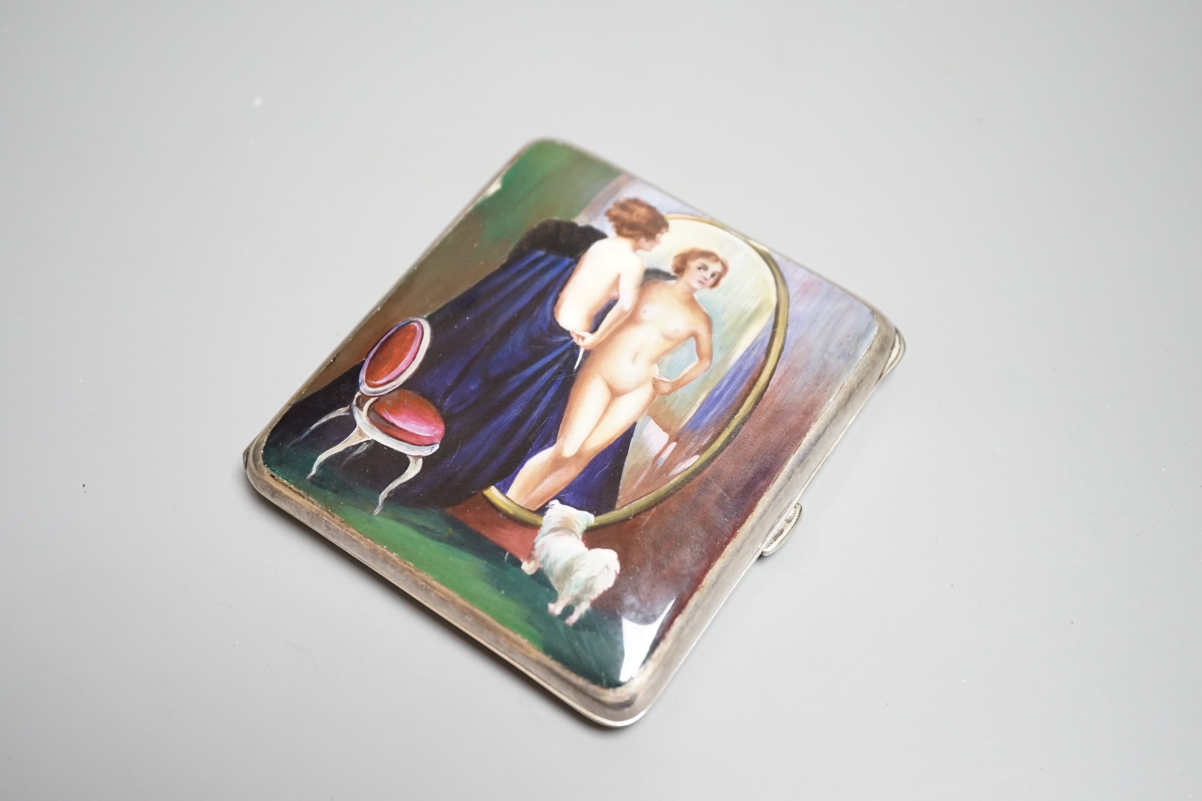 A Continental silver plated cigarette case, early 20th century, lid with erotic enamel scene of naked lady standing in front of a cheval mirror, gilt interior stamped ALPARP, height 8.5cms.